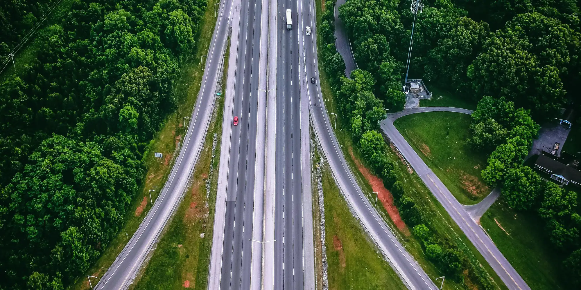 An interstate running through woodland, with on and off ramps, seen from above